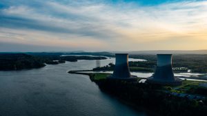 Cooling towers of a nuclear power plant situated next to a river from which cooling water is extracted.