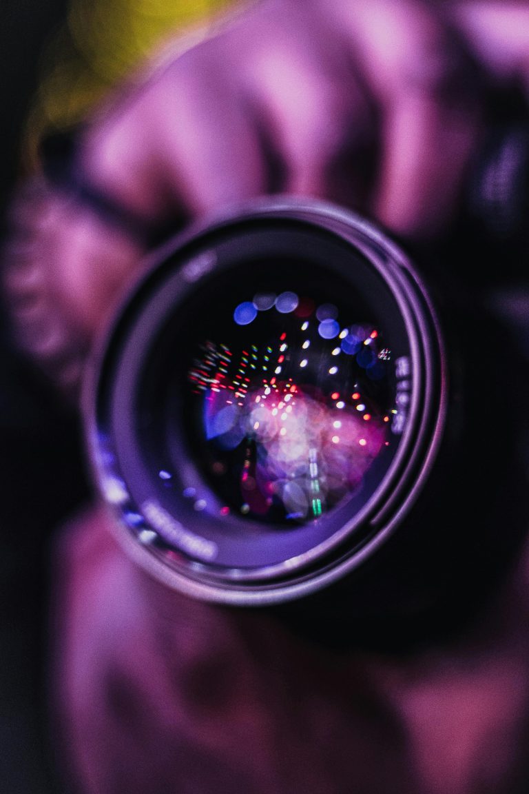 A closeup shot of a camera lens reflecting lights