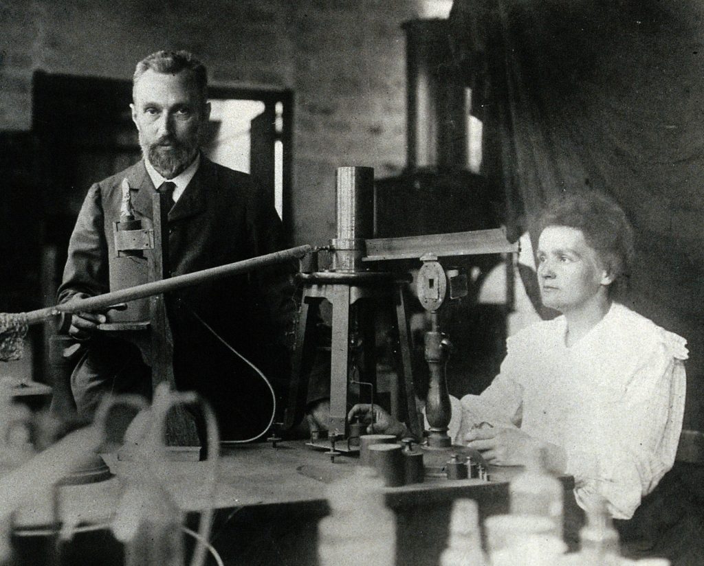 Pierre and Marie in the laboratory, demonstrating experimental apparatus used to detect the ionisation of air