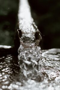An image of a metal gutter with liquid pouring out, resembling the molten-metal coolant within a lead-cooled fast reactor.