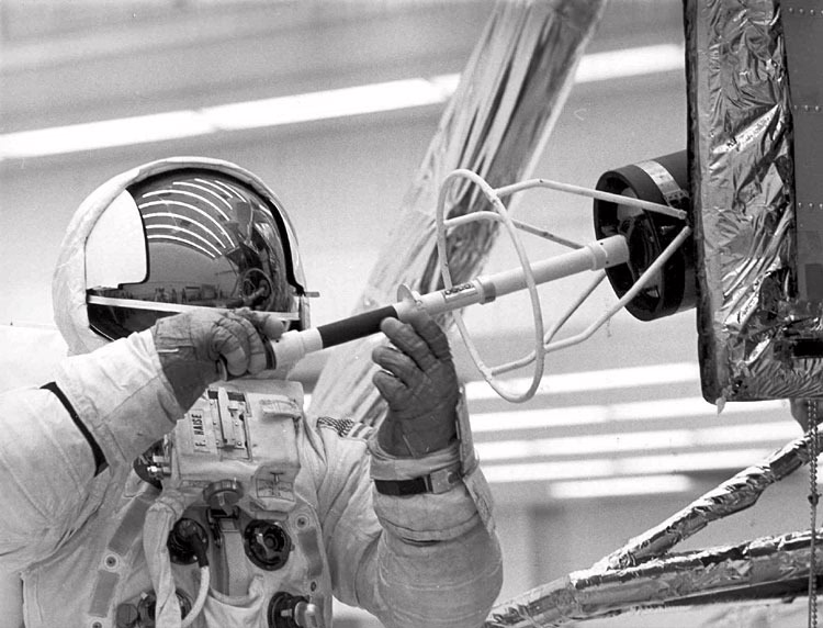 Astronaut Fred Haise extracts the fuel element for a SNAP-26 RTG from the transport cask on the side of the Lunar Module